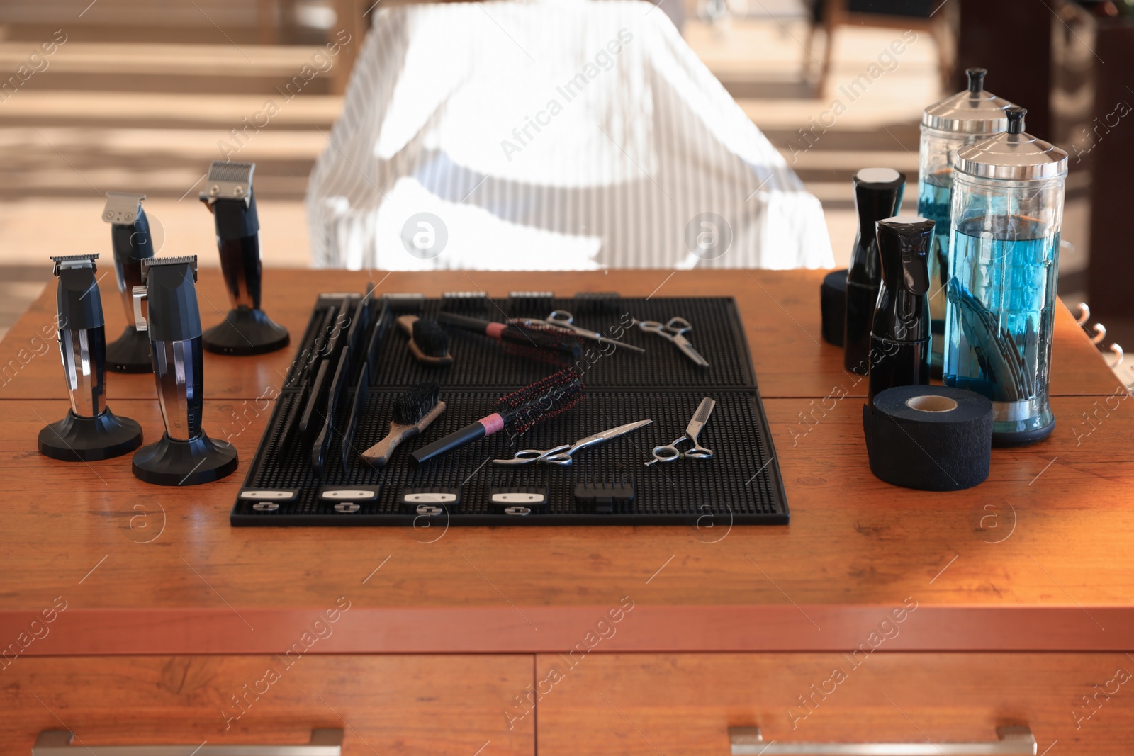 Photo of Stylish hairdresser's workplace with professional tools and cosmetic products in barbershop