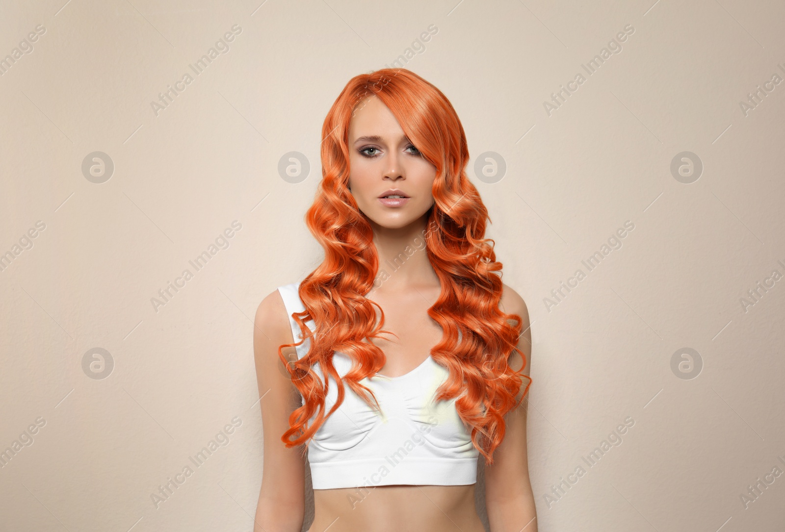 Image of Beautiful woman with long orange hair on beige background