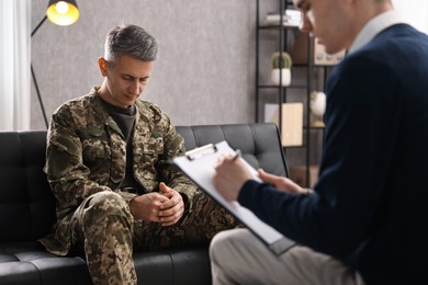 Professional psychotherapist working with military man in office