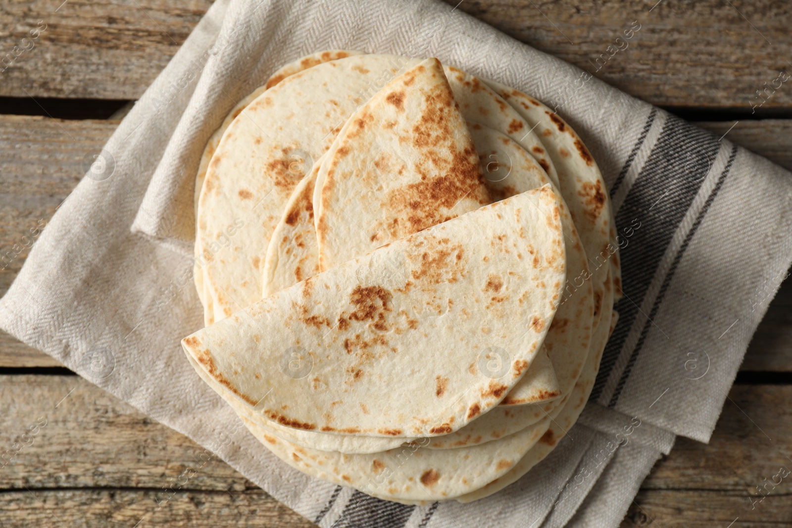 Photo of Tasty homemade tortillas on wooden table, top view