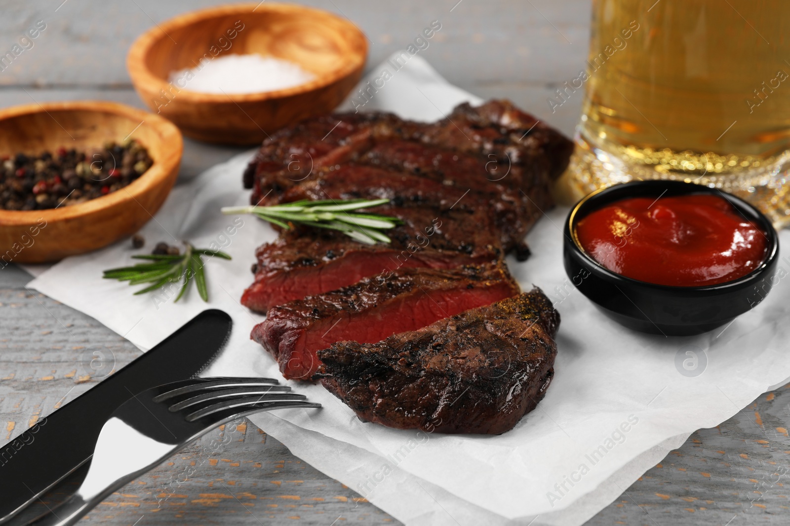 Photo of Delicious fried steak served on grey wooden table, closeup