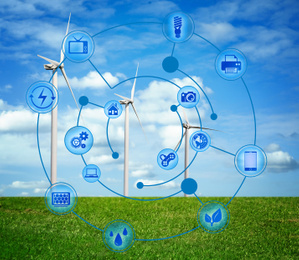 Image of Alternative energy source. Wind turbines in field under blue sky and scheme