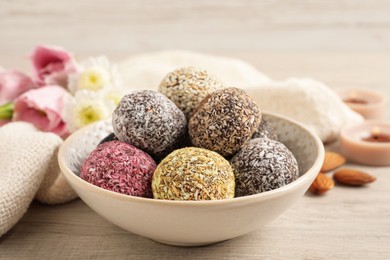 Photo of Different delicious vegan candy balls on white wooden table
