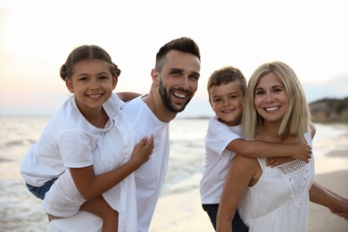 Photo of Happy family on beach near sea. Summer vacation