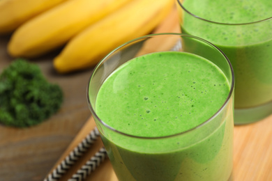 Photo of Tasty fresh kale smoothie on table, closeup