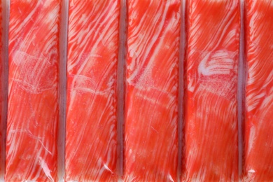 Photo of Top view on fresh crab sticks in pack as background, closeup