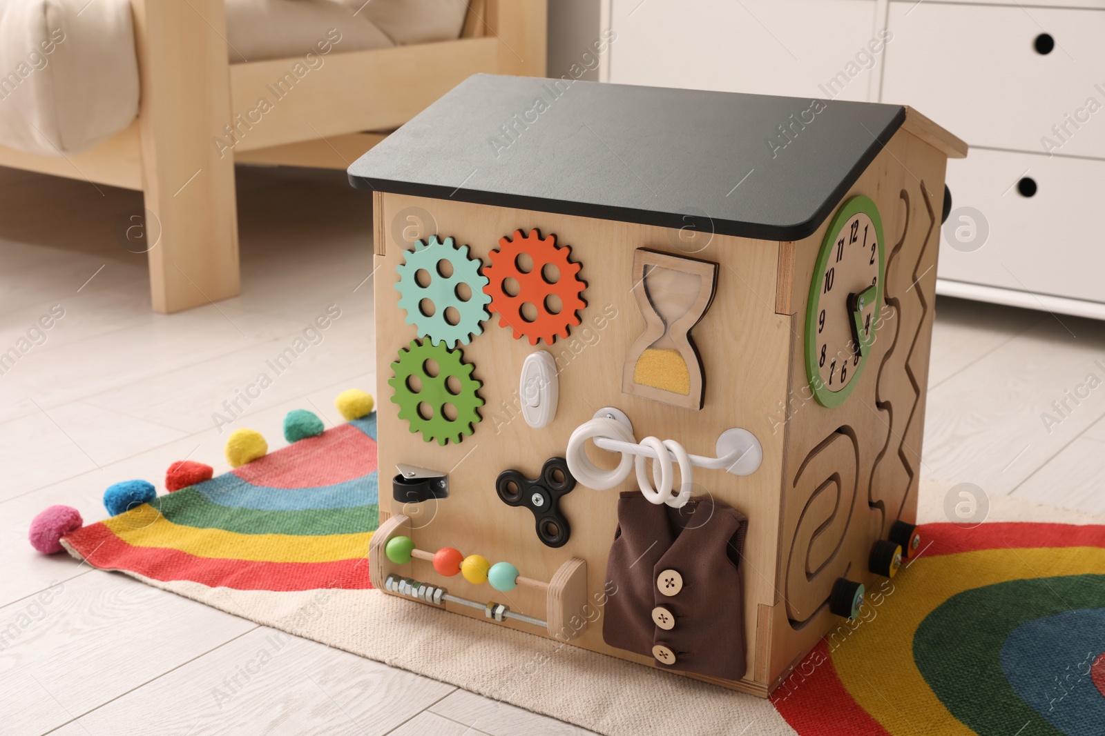 Photo of Busy board house on floor indoors. Baby sensory toy