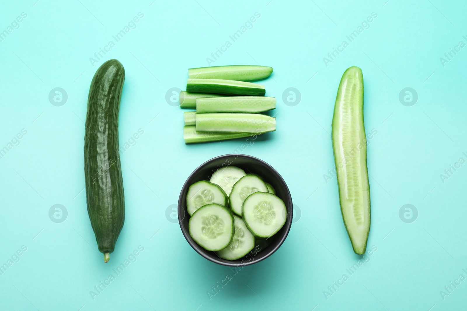 Photo of Fresh ripe cucumbers on light blue background, flat lay