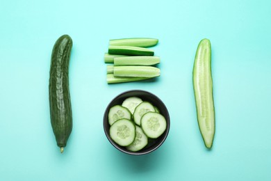 Photo of Fresh ripe cucumbers on light blue background, flat lay