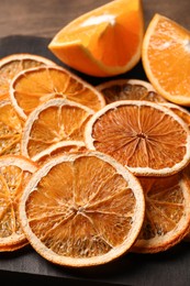 Photo of Dry orange slices on wooden board, closeup