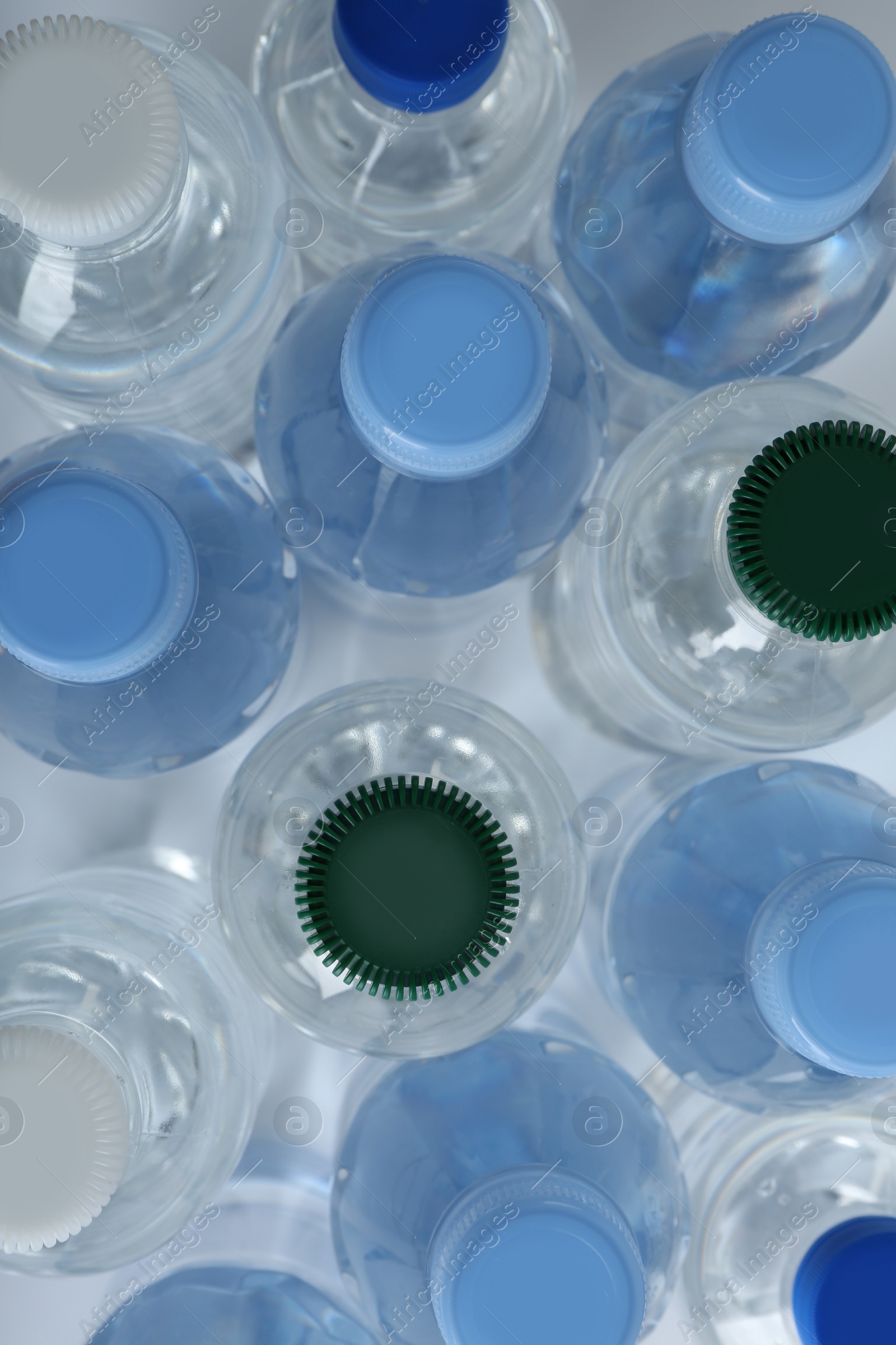 Photo of Rows of different plastic bottles with  water on white background, flat lay