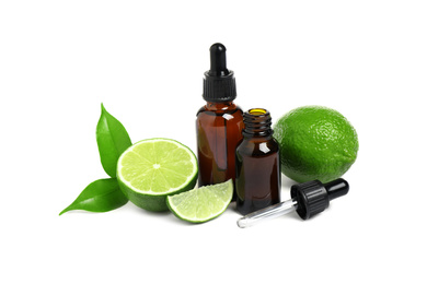 Lime essential oil in bottles and citrus fruits isolated on white