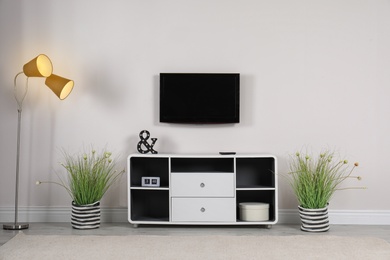Photo of Living room interior with plasma TV on light wall