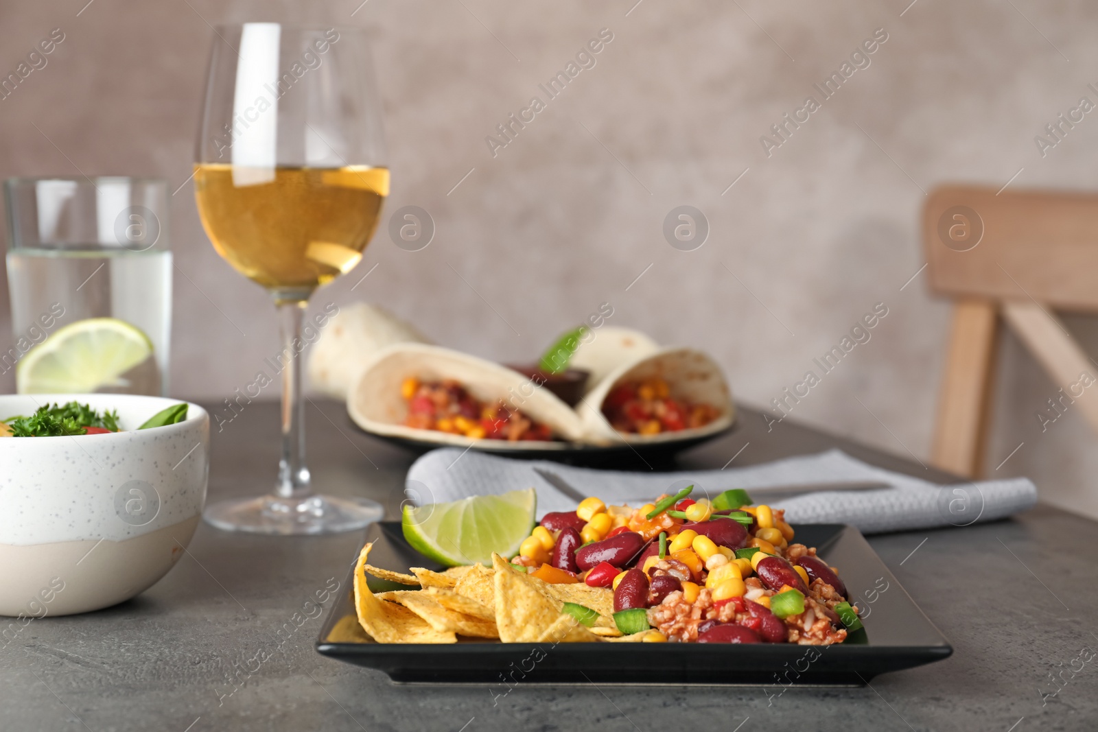 Photo of Plate with tasty chili con carne served on gray table