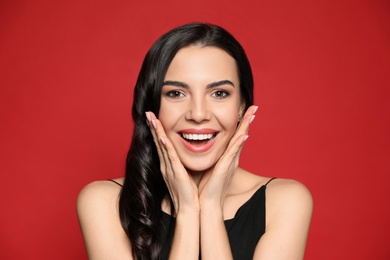 Photo of Portrait of surprised woman on red background