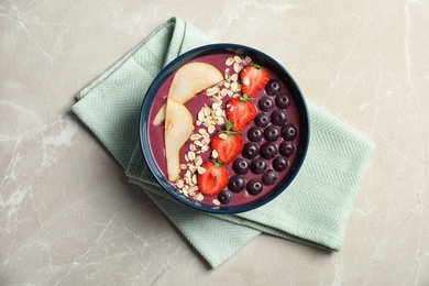 Photo of Flat lay composition with bowl of tasty acai smoothie on gray table