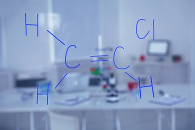 Photo of Chemical formula written by medical students on glass whiteboard in laboratory