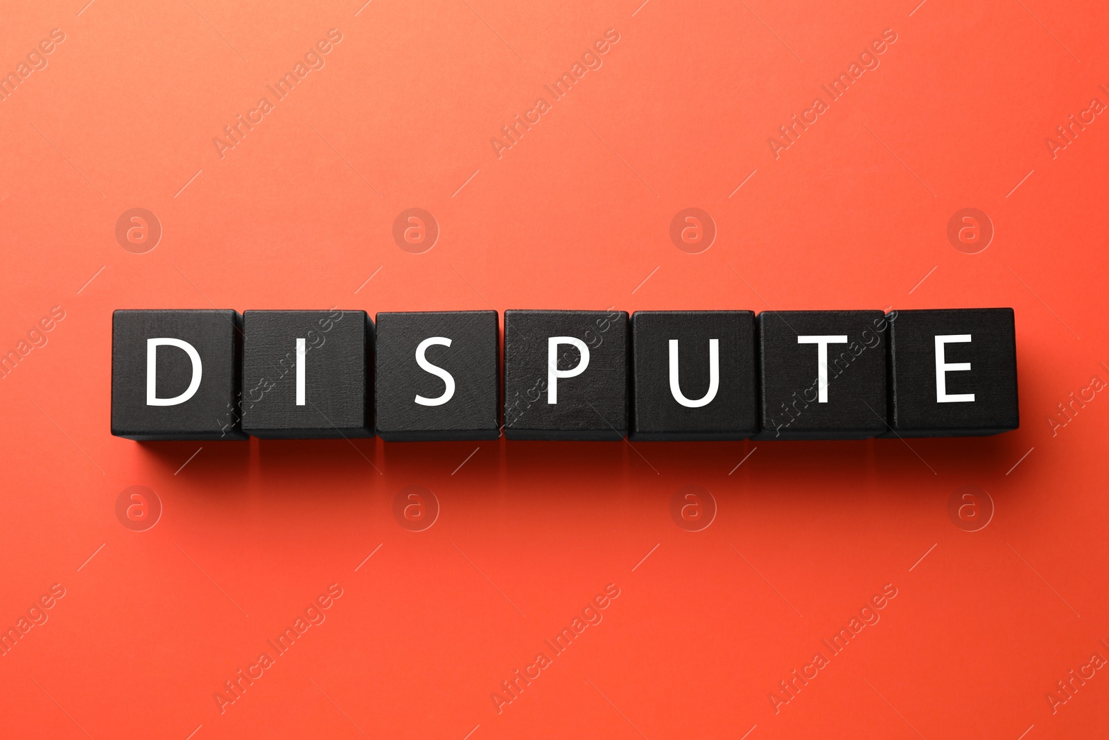 Photo of Word Dispute made with black cubes on red background, top view