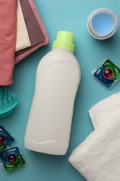Photo of Flat lay composition with bottle of fabric softener on light blue wooden table