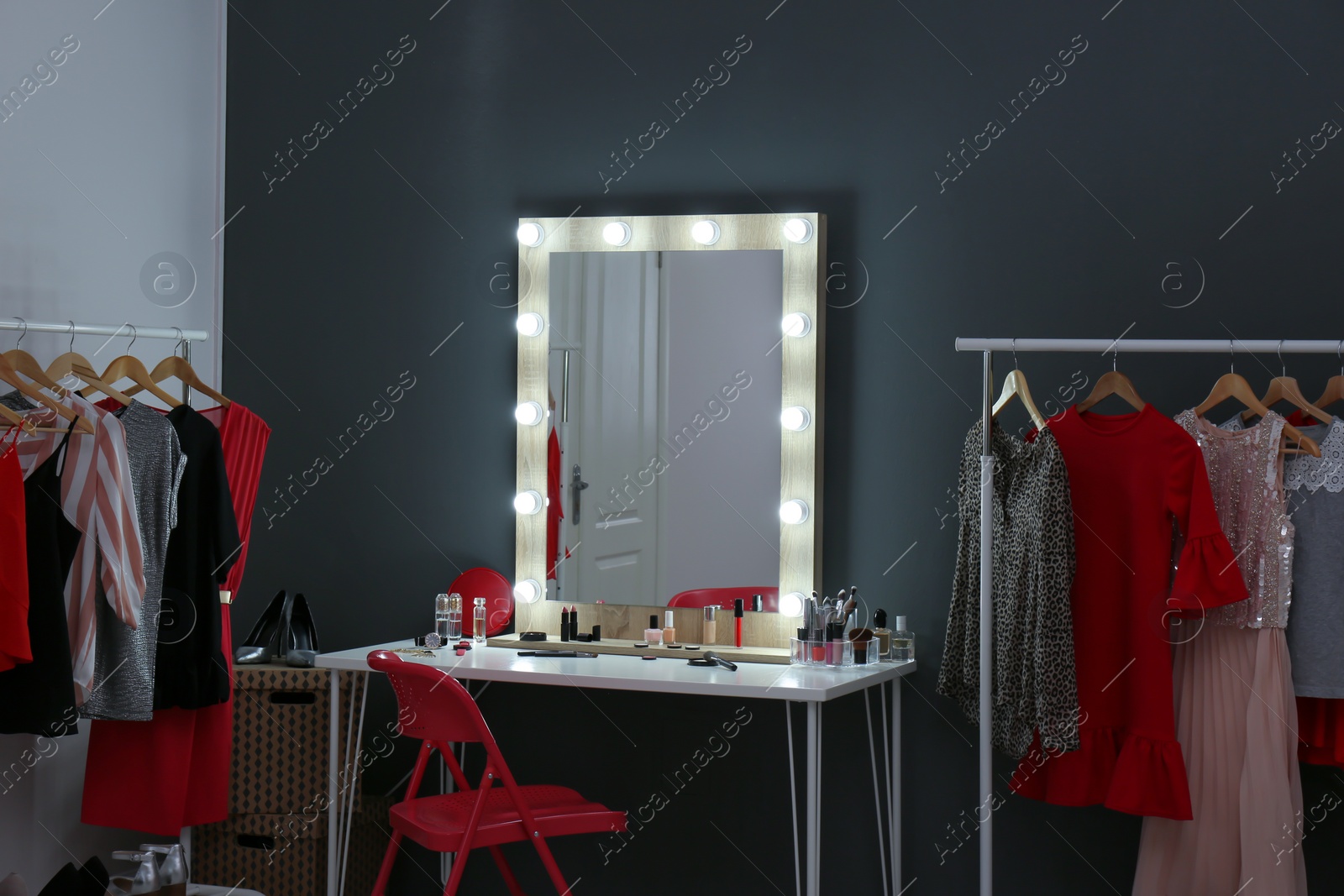 Photo of Stylish room with dressing table, mirror and wardrobe racks