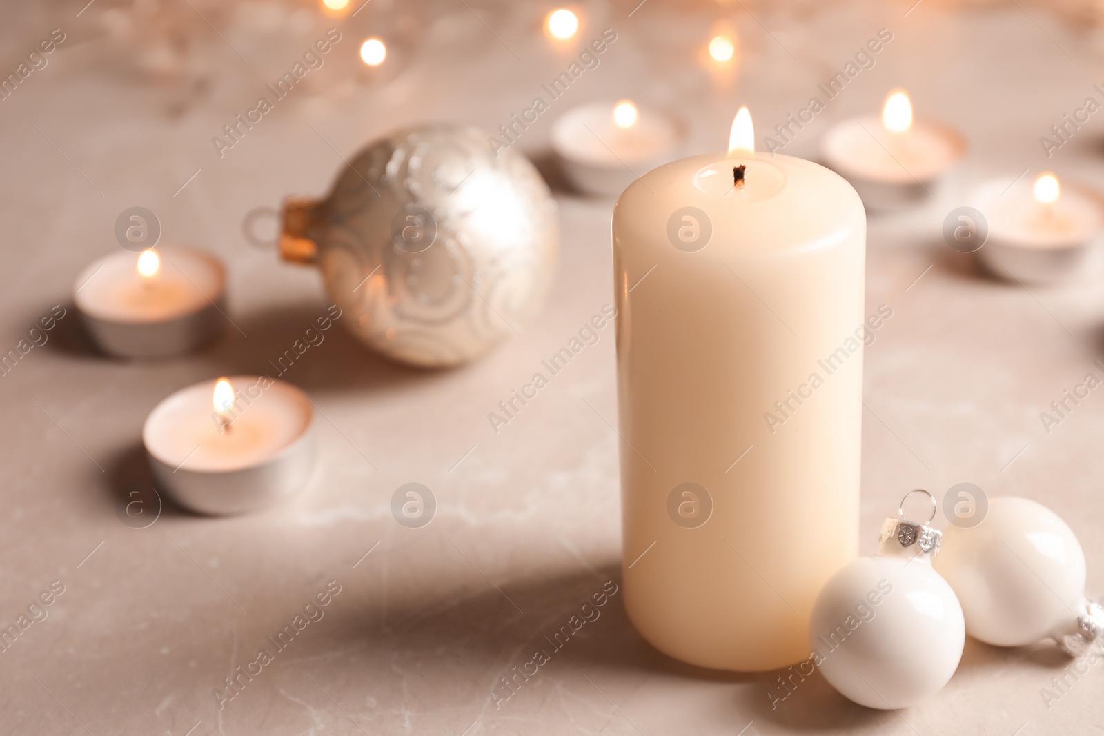 Photo of Burning wax candle and Christmas decorations on table