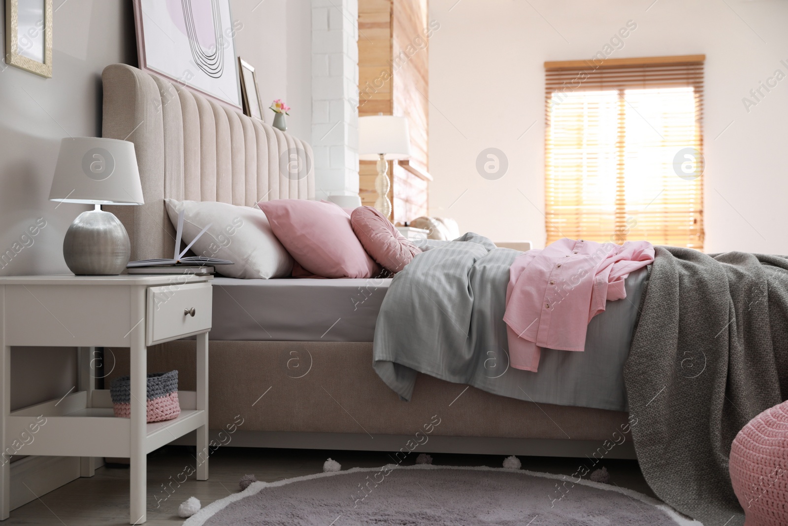 Photo of Bed with stylish linens near grey wall in room