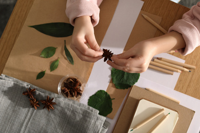 Little girl working with natural materials at table, top view. Creative hobby