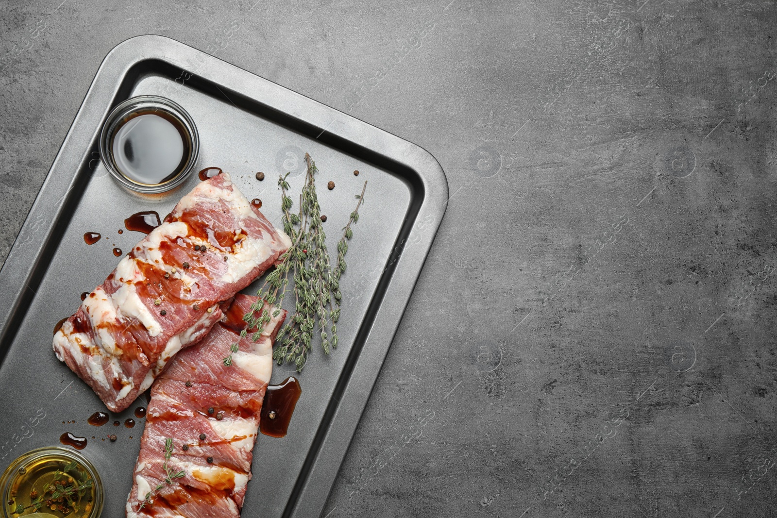 Photo of Fresh raw ribs on grey table, top view. Space for text