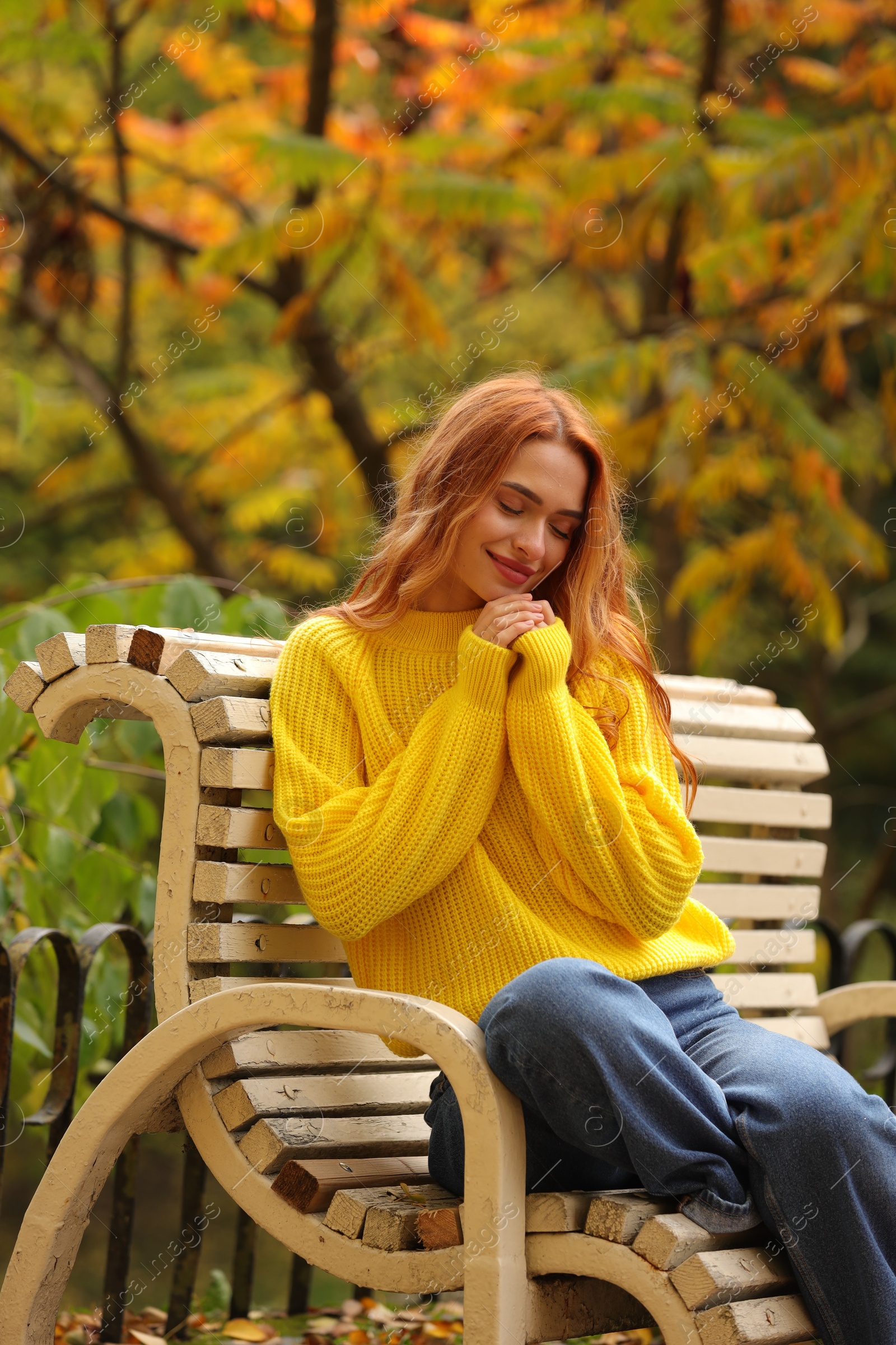 Photo of Beautiful woman sitting on bench in autumn park