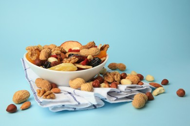Photo of Bowl with mixed dried fruits and nuts on light blue background