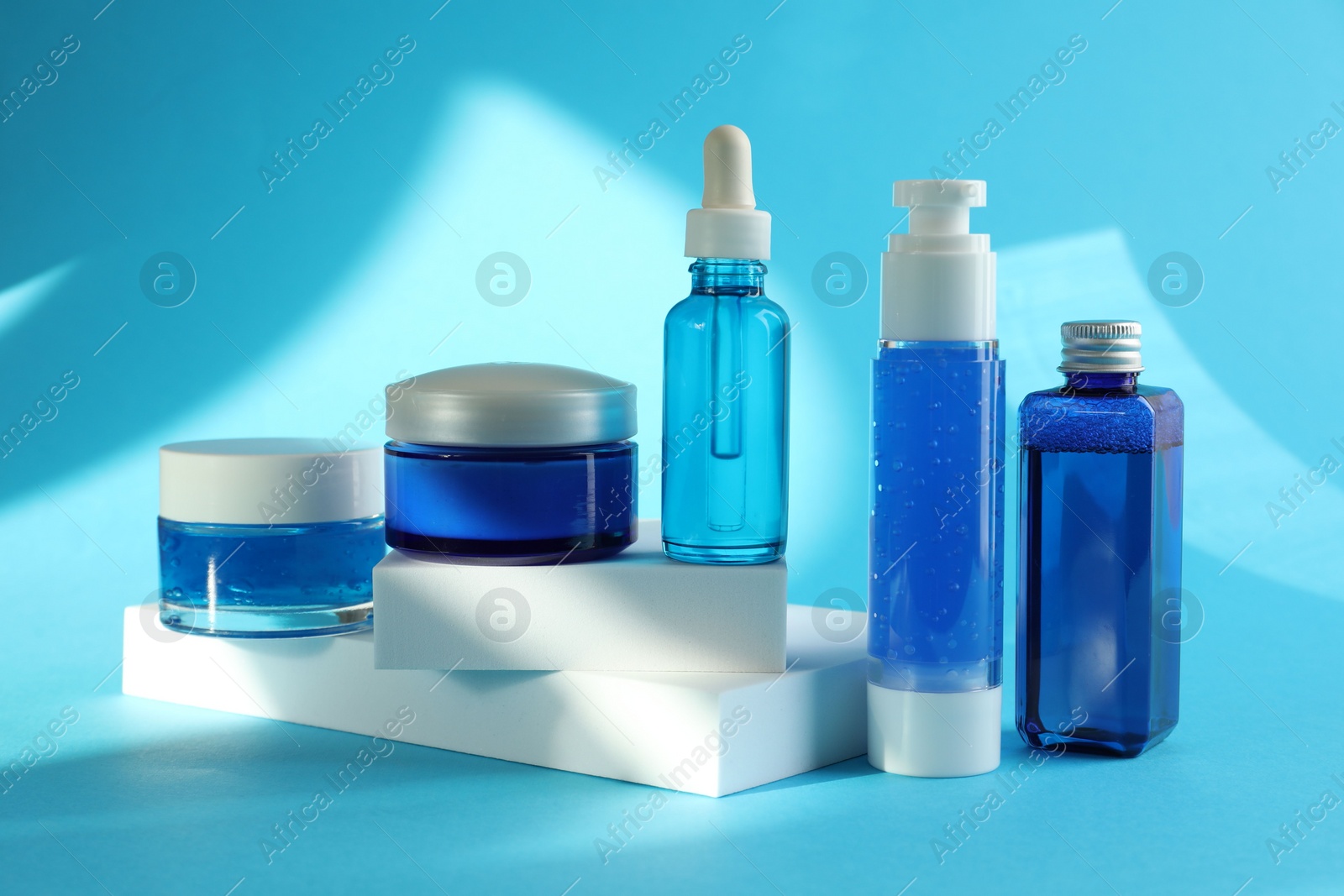 Photo of Set of luxury cosmetic products on light blue background