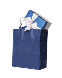 Photo of Blue paper shopping bag with gift box on white background