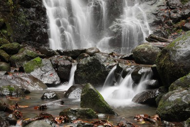 Photo of Picturesque view of beautiful mountain waterfall and rocks outdoors