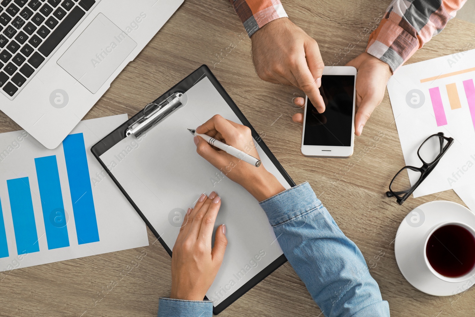 Photo of Business trainer and client working at table in office, top view