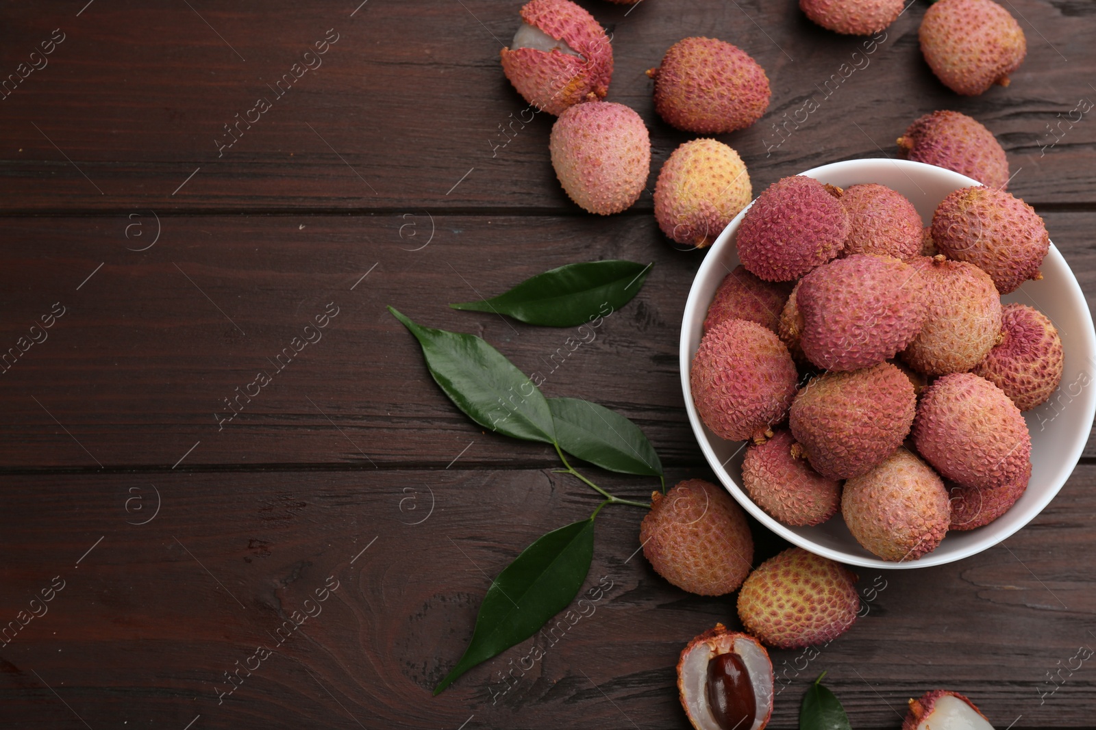 Photo of Fresh ripe lychee fruits on wooden table, flat lay. Space for text