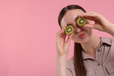 Photo of Woman covering eyes with halves of kiwi on pink background, space for text