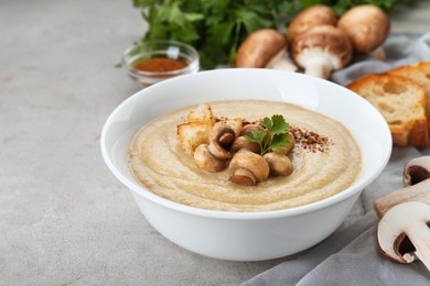Photo of Delicious cream soup with mushrooms and croutons on beige textured table
