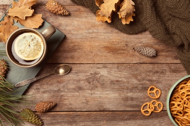 Photo of Flat lay composition with hot cozy drink and autumn leaves on wooden background. Space for text