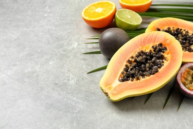 Photo of Fresh ripe papaya and other fruits on light grey table. Space for text