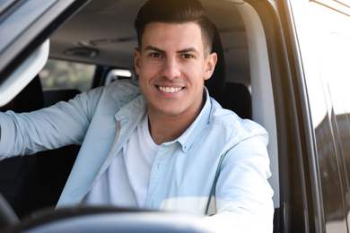 Photo of Handsome man driving his modern car, view from outside