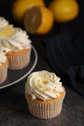 Photo of Delicious cupcakes with white cream and lemon zest on table