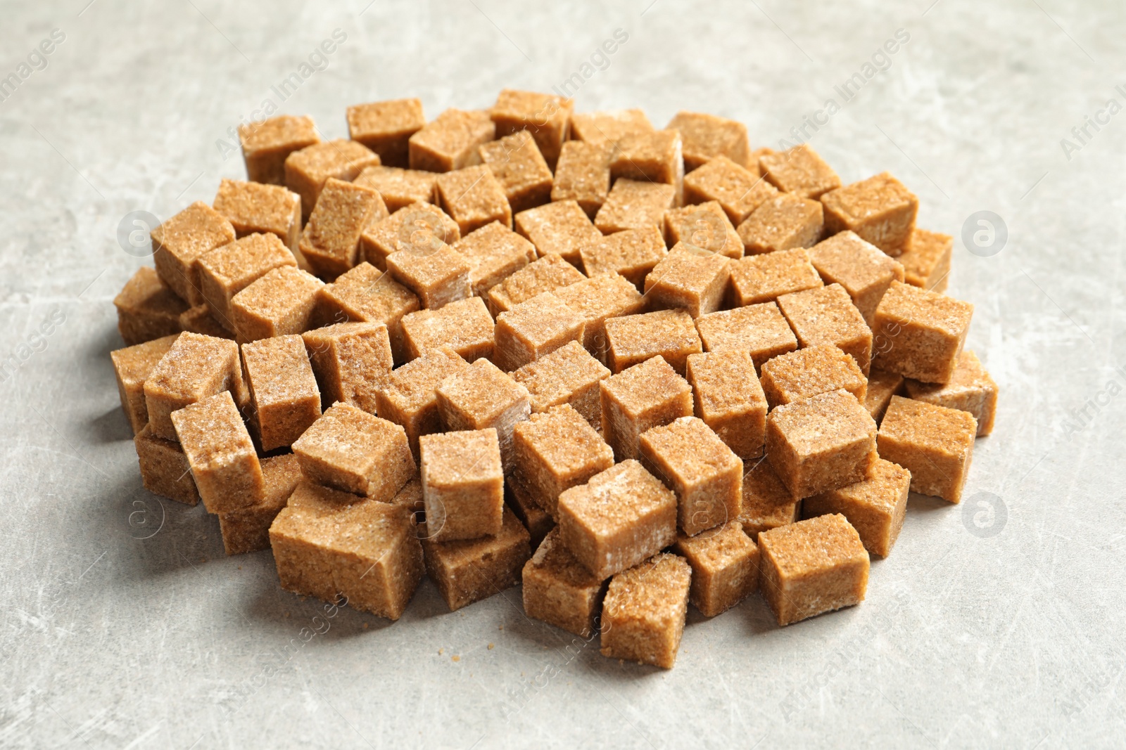 Photo of Cubes of brown sugar on gray table