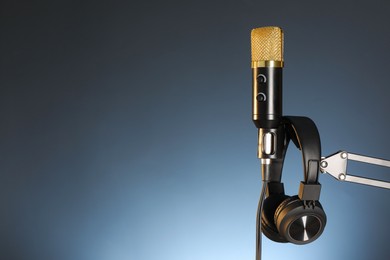 Photo of Stand with microphone and headphones on dark background, space for text. Sound recording and reinforcement