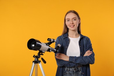 Happy astronomer with telescope on orange background, space for text