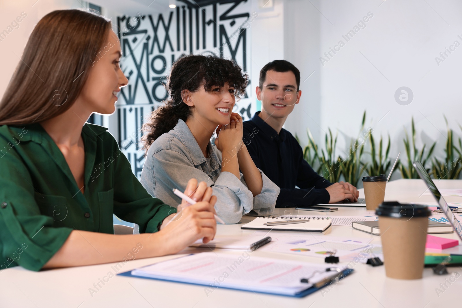 Photo of Team of employees working together at table in office. Startup project