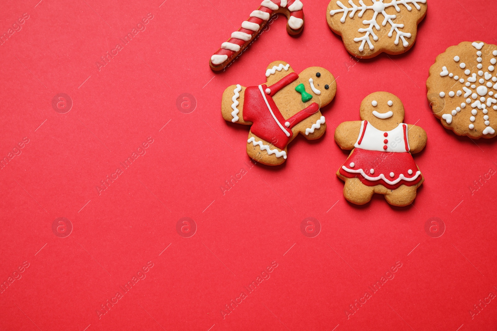 Photo of Flat lay composition with tasty homemade Christmas cookies on red background, space for text