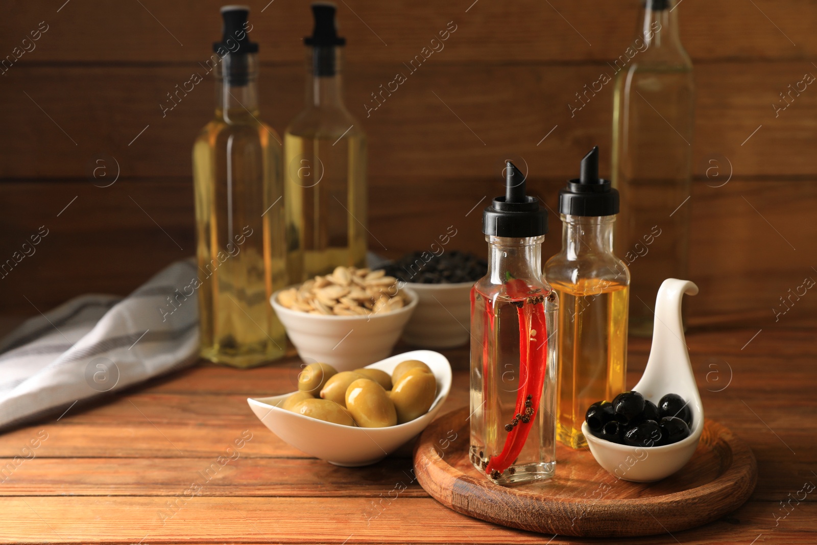 Photo of Different cooking oils and ingredients on wooden table