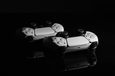 Photo of Wireless game controllers on black mirror surface