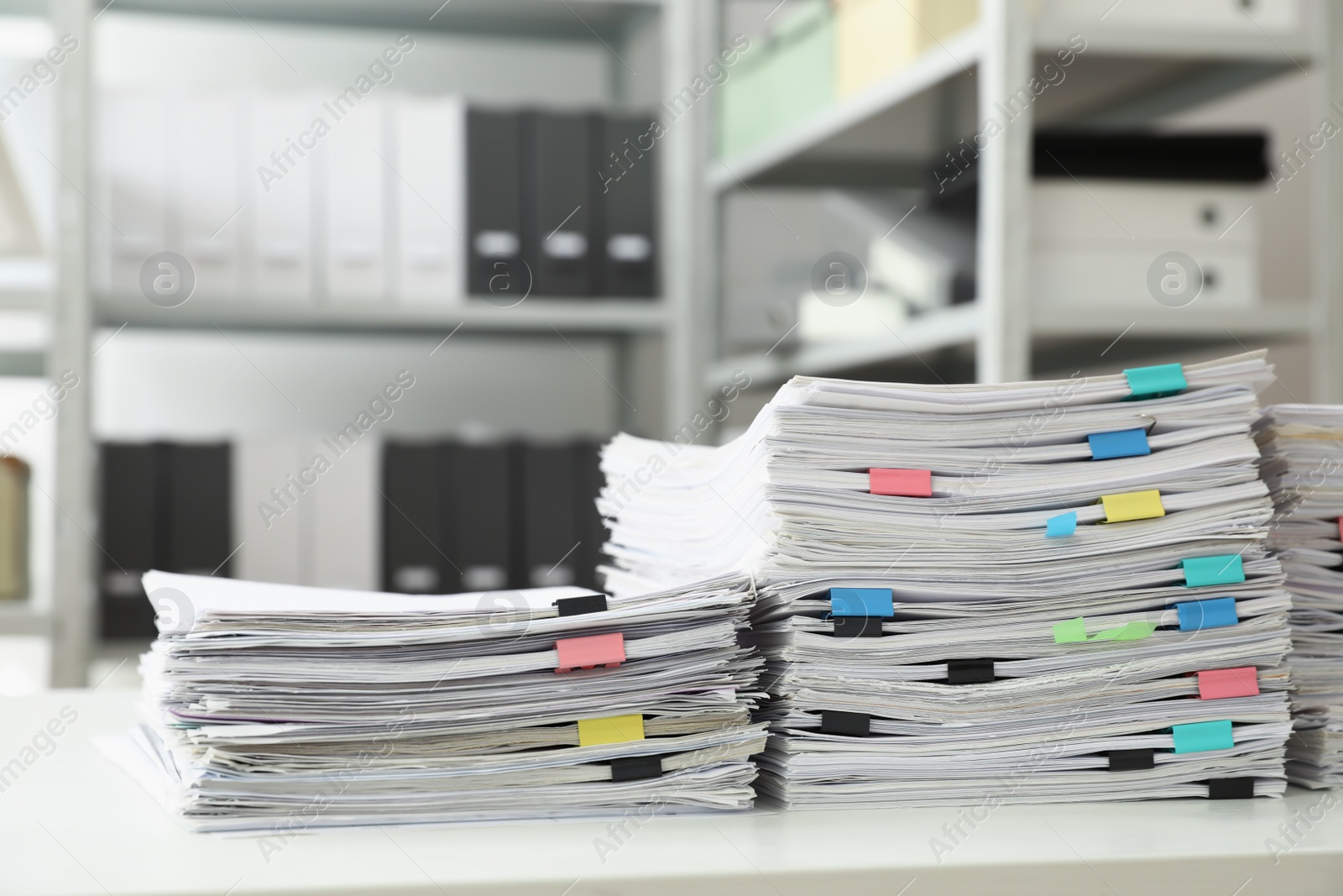 Photo of Stacks of documents with paper clips on office desk