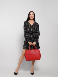 Young woman with stylish bag on white background,